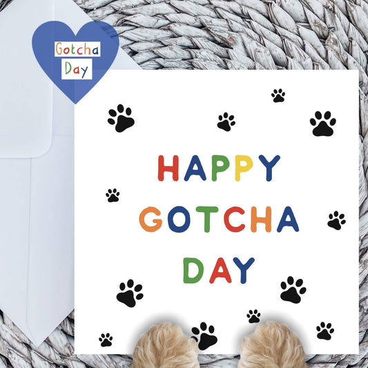 Greeting card with 'Happy Gotcha Day' text and paw prints on a textured surface.